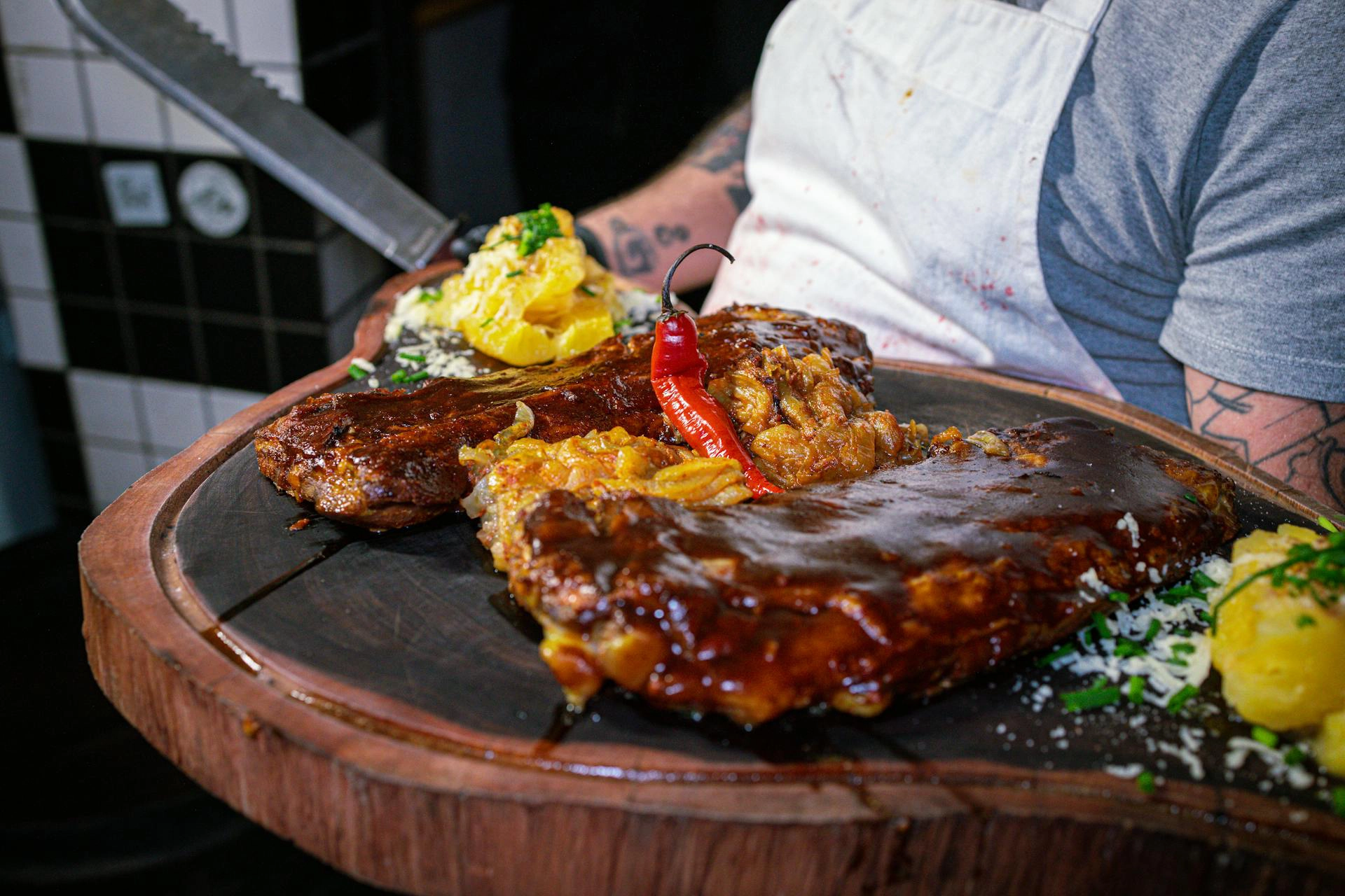 Ein Holzbrett mit gegrillten Rippchen und Beilagen