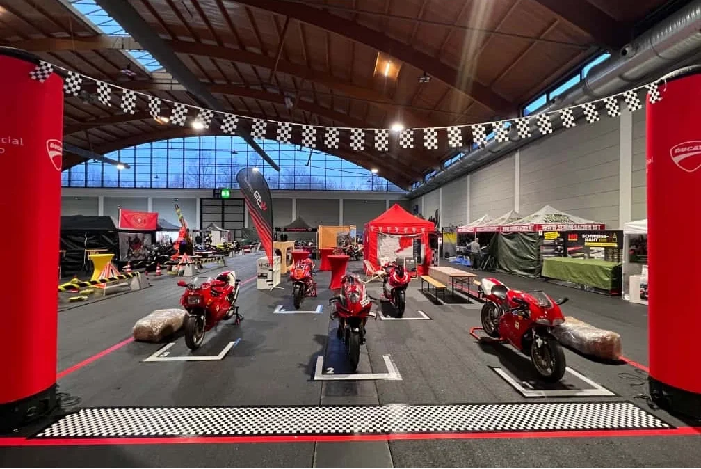 Ausgestellte, rote Motorräder in einer Messehalle