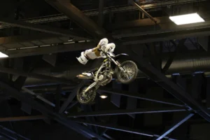 Ein Stuntfahrer mit einem Cross-Motorrad fliegt durch die Luft