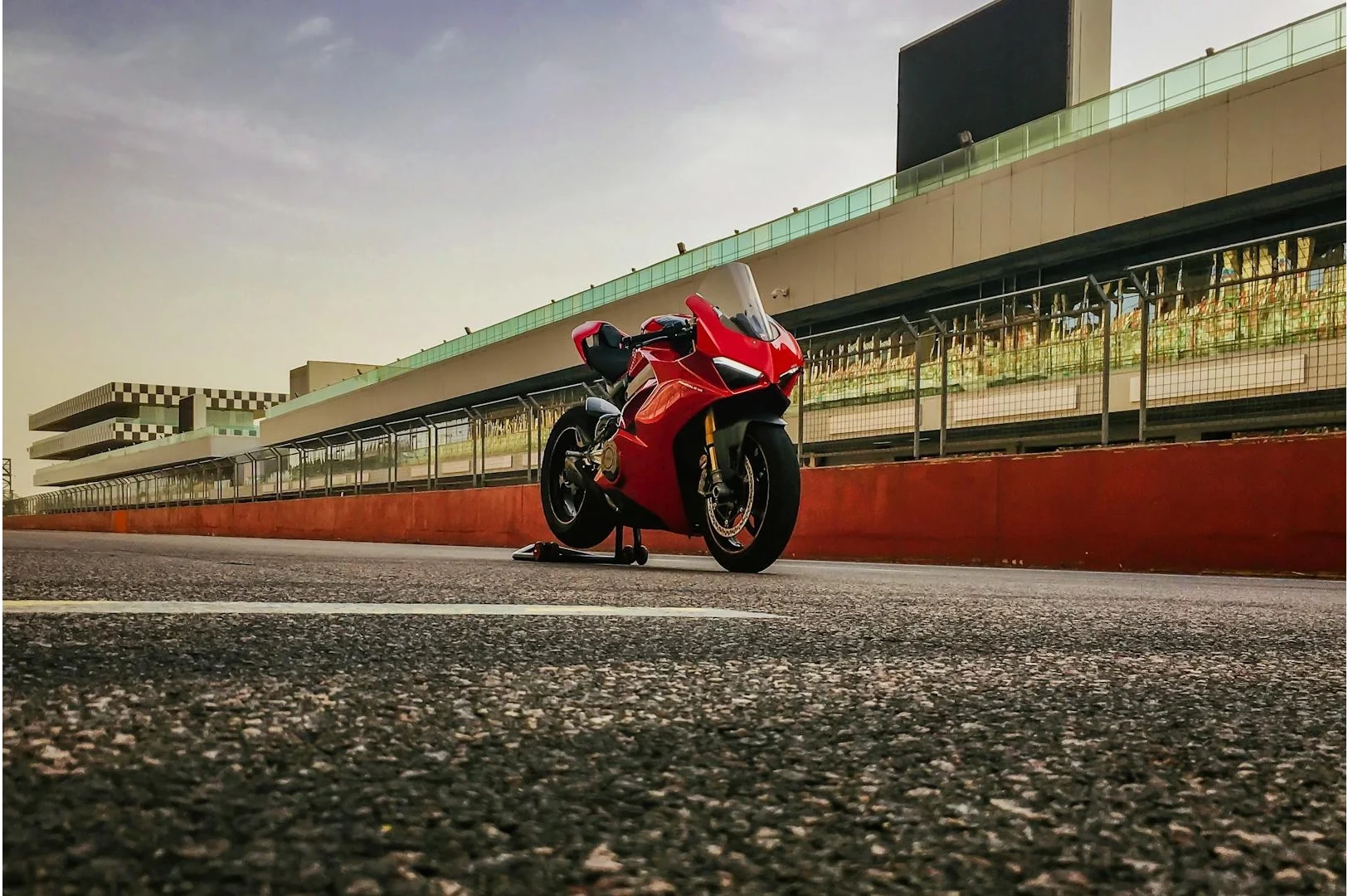 Rotes Motorrad steht auf einer Rennstrecke