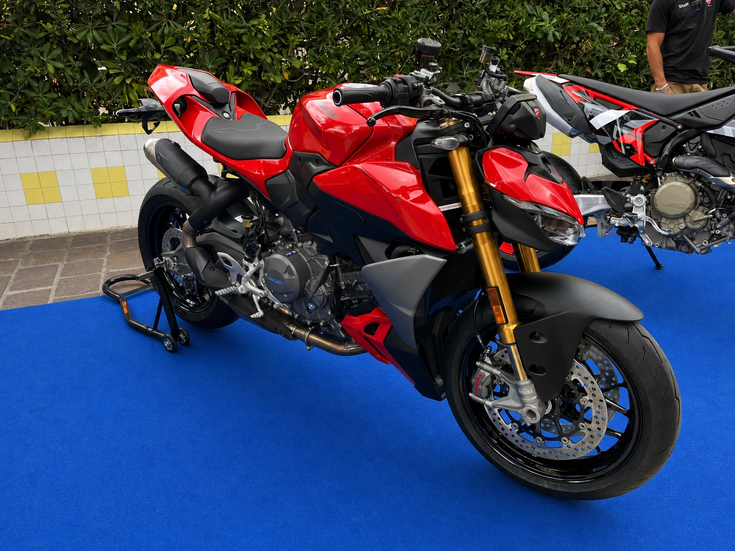Eine rote Ducati Streetfighter auf einem blauen Teppich